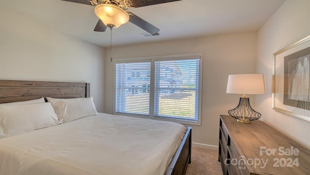 carpeted bedroom featuring ceiling fan and multiple windows