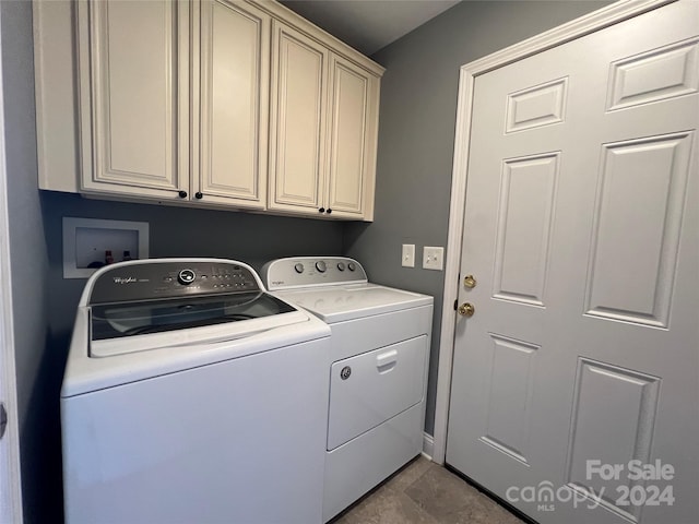 clothes washing area with cabinets and separate washer and dryer