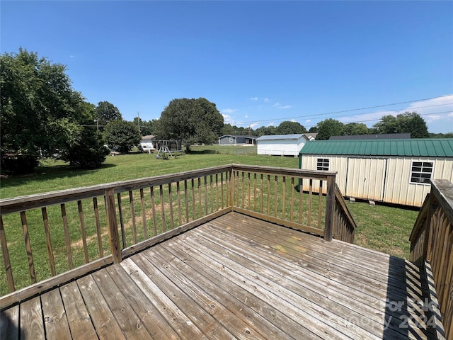 wooden terrace featuring a yard and a storage shed