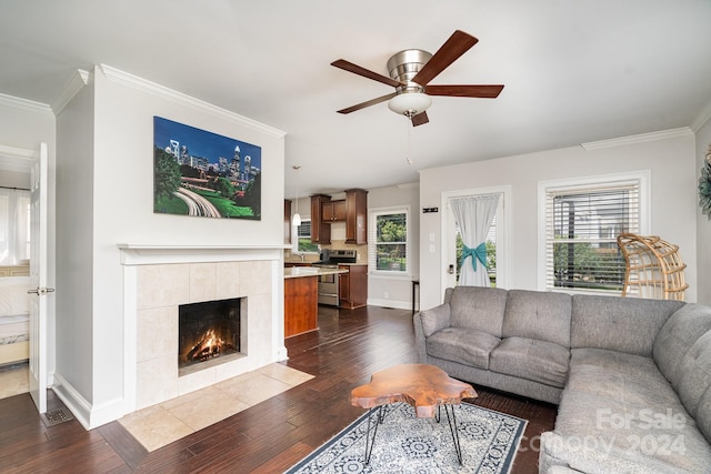 living room with ceiling fan, plenty of natural light, dark hardwood / wood-style floors, and crown molding