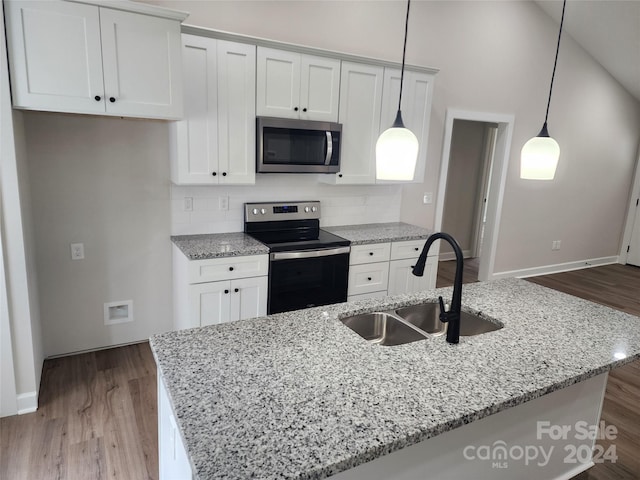 kitchen with sink, light wood-type flooring, white cabinetry, stainless steel appliances, and decorative light fixtures