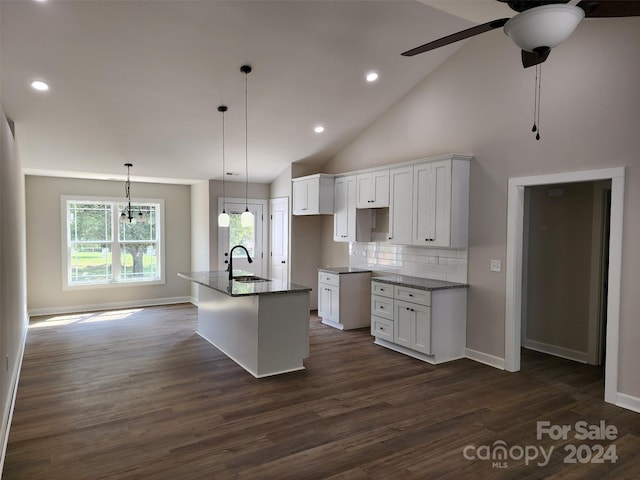 kitchen with a center island with sink, stone countertops, white cabinets, and dark hardwood / wood-style flooring