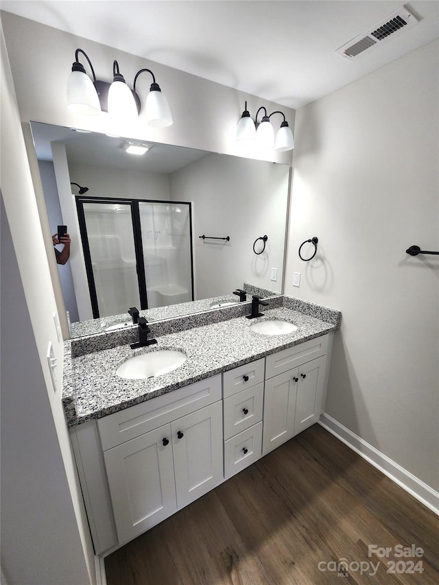 bathroom with vanity, hardwood / wood-style floors, and a shower with door