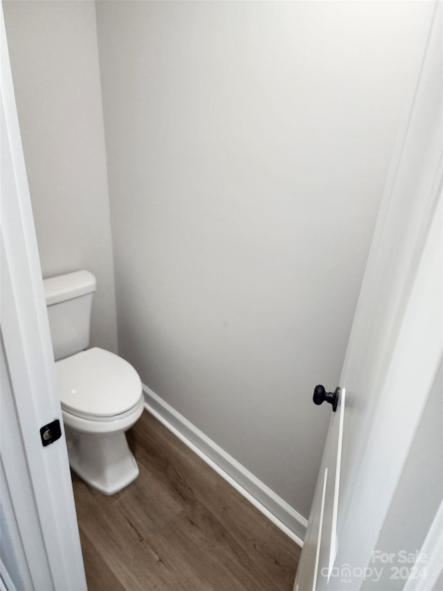 bathroom with toilet and hardwood / wood-style flooring