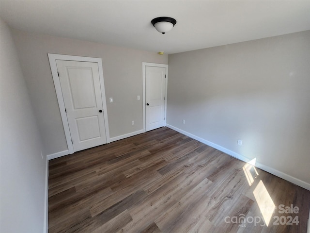 unfurnished bedroom with dark hardwood / wood-style floors