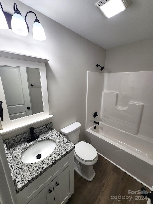 full bathroom with vanity, hardwood / wood-style floors, toilet, and tub / shower combination