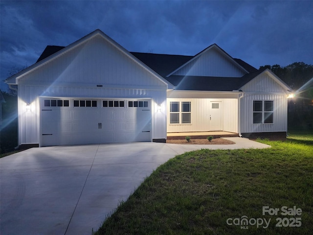 view of front of home with an attached garage, a front lawn, and concrete driveway