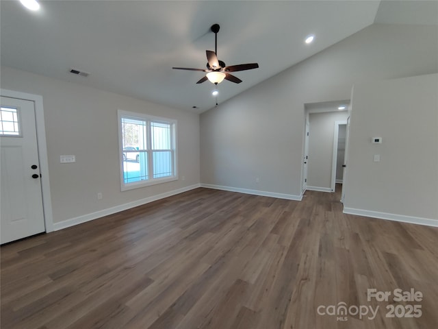 interior space with vaulted ceiling, baseboards, visible vents, a ceiling fan, and wood finished floors