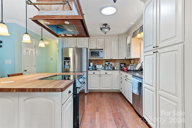 kitchen with crown molding, appliances with stainless steel finishes, white cabinetry, decorative light fixtures, and wood counters