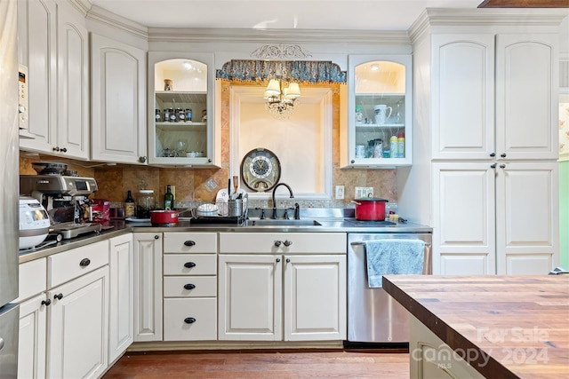 kitchen with butcher block counters, tasteful backsplash, white cabinetry, stainless steel dishwasher, and sink