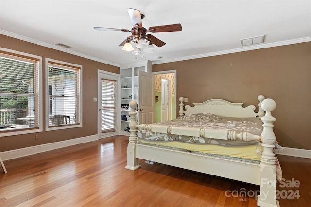 bedroom with ceiling fan, ornamental molding, and wood-type flooring