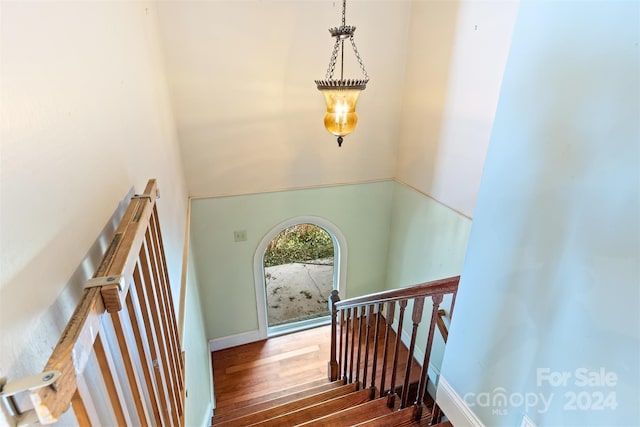 stairway featuring hardwood / wood-style flooring and a towering ceiling