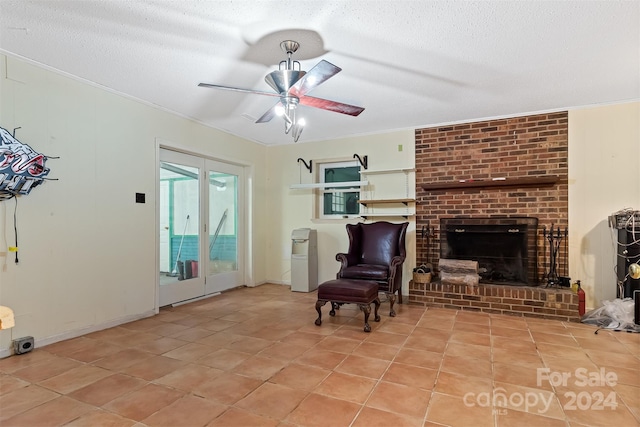 living room featuring a fireplace, a textured ceiling, light tile patterned floors, and ceiling fan