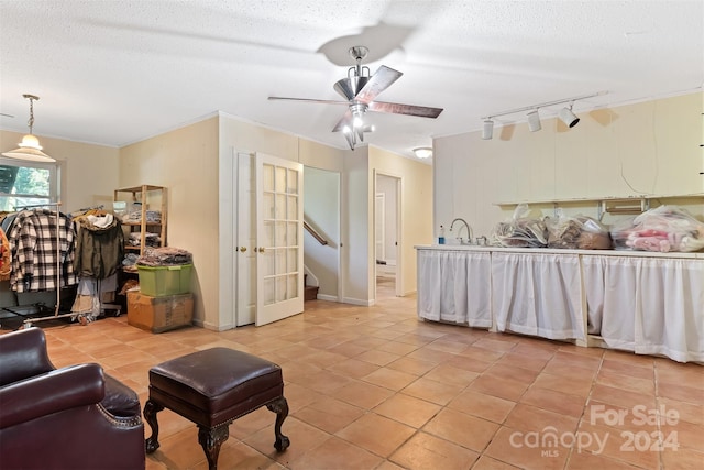 living room featuring ceiling fan, rail lighting, light tile patterned floors, and a textured ceiling