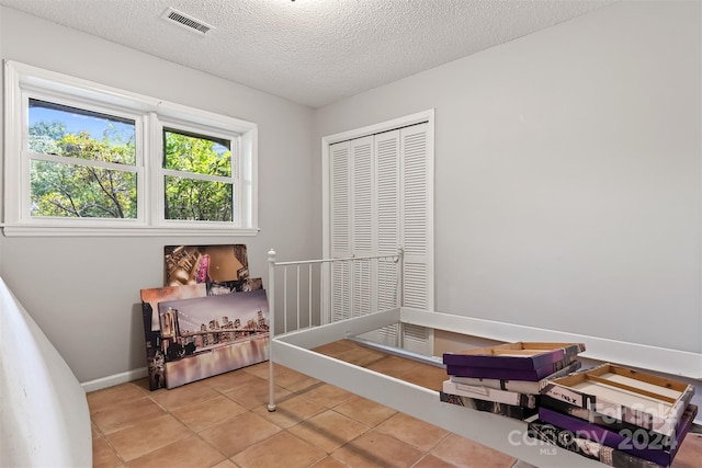 bedroom with a textured ceiling and tile patterned flooring