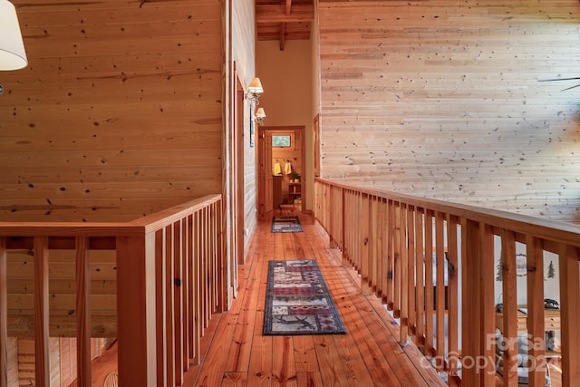 hallway with beam ceiling, light wood-type flooring, and wood ceiling