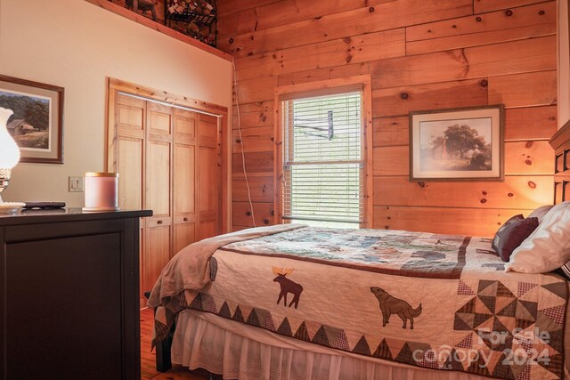 bedroom featuring a closet and wood walls