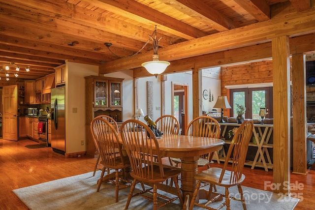 dining area featuring wooden ceiling, light wood-style flooring, french doors, and beam ceiling