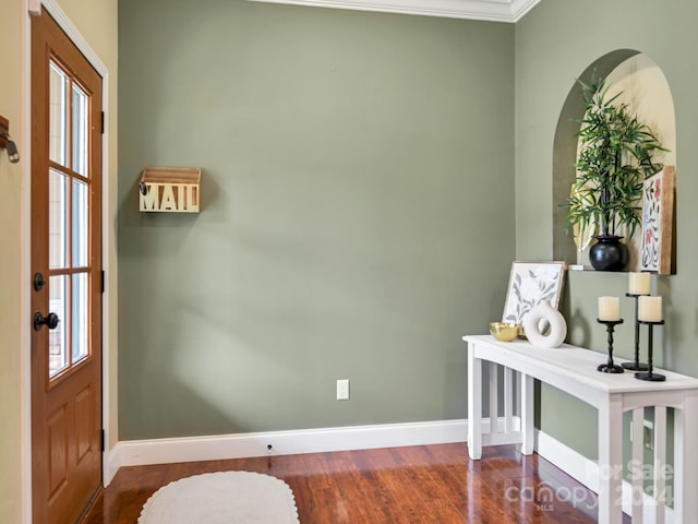 entrance foyer with a healthy amount of sunlight, dark hardwood / wood-style floors, and crown molding