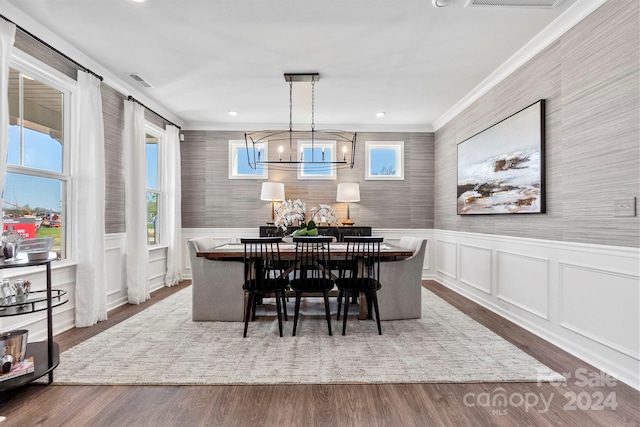 dining space featuring dark hardwood / wood-style flooring, crown molding, and plenty of natural light