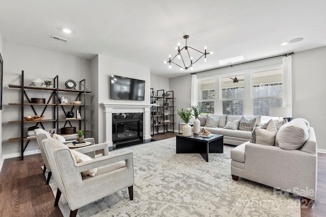 living room with a premium fireplace, a chandelier, and hardwood / wood-style flooring