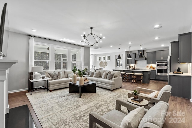 living room with hardwood / wood-style floors and a notable chandelier