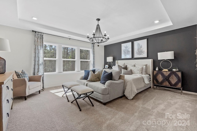 bedroom featuring light carpet, a tray ceiling, and a notable chandelier