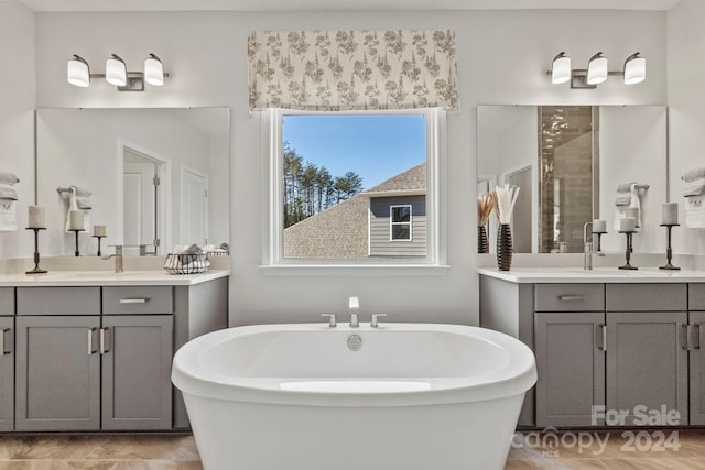 bathroom featuring shower with separate bathtub, a healthy amount of sunlight, and vanity