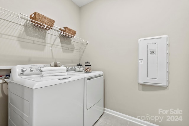 laundry area featuring light tile patterned floors and washing machine and dryer