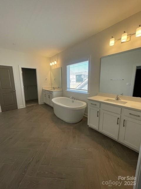 full bath with a soaking tub, two vanities, and a sink