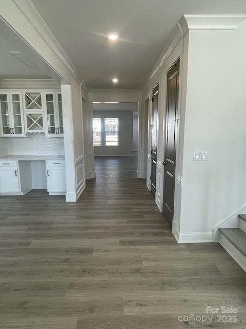 hallway with baseboards, stairway, dark wood finished floors, and crown molding