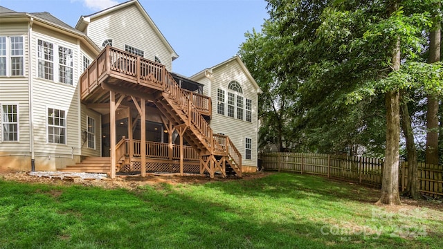 rear view of house with a wooden deck and a lawn