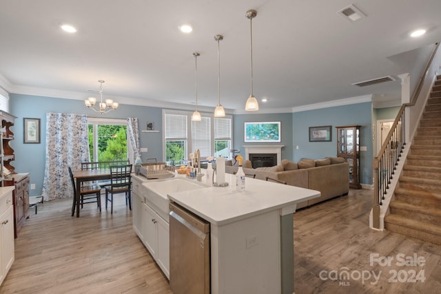 kitchen with sink, white cabinetry, decorative light fixtures, stainless steel dishwasher, and a kitchen island with sink