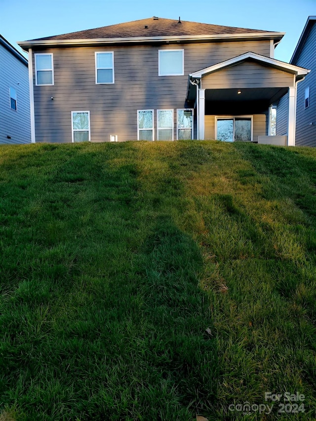 rear view of house featuring a yard