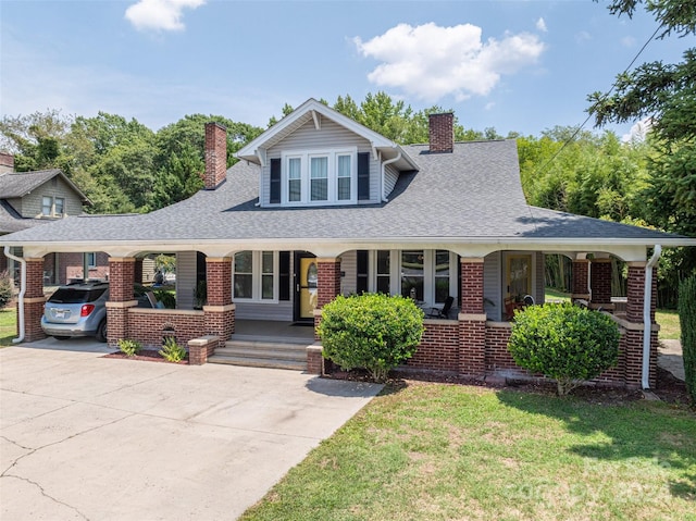 view of front facade featuring a carport, a porch, and a front yard