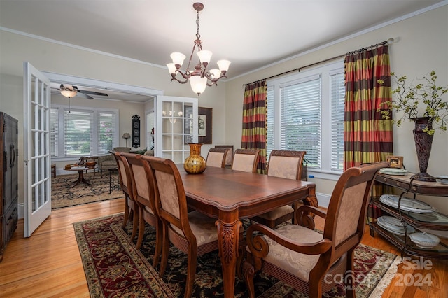 dining room with ceiling fan with notable chandelier, crown molding, and light hardwood / wood-style flooring