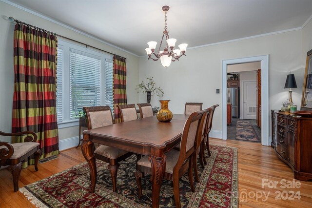 dining room with light hardwood / wood-style flooring and ornamental molding