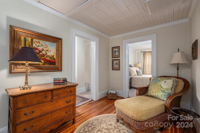 sitting room with light wood-type flooring, wood ceiling, and crown molding