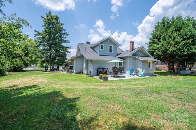 rear view of house featuring a patio area and a yard