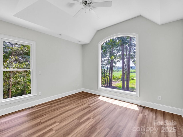 unfurnished room with ceiling fan, a healthy amount of sunlight, and hardwood / wood-style floors