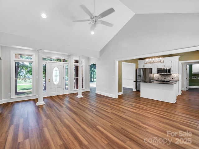 unfurnished living room featuring ceiling fan, dark hardwood / wood-style floors, and high vaulted ceiling