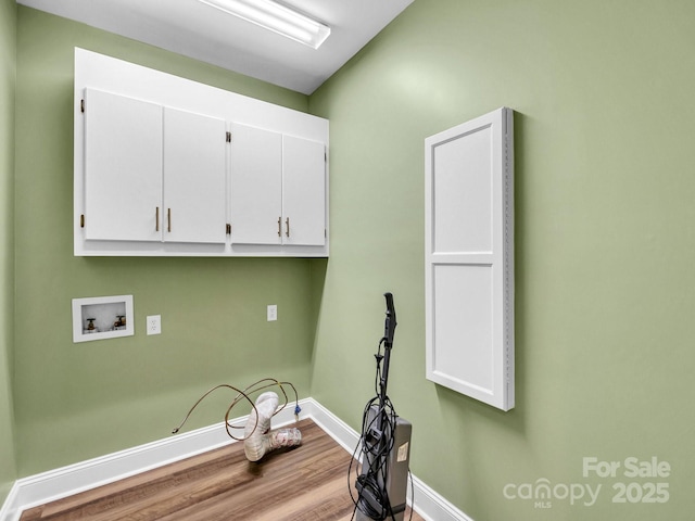 laundry room featuring hardwood / wood-style floors, washer hookup, and cabinets