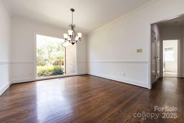 empty room featuring a notable chandelier, plenty of natural light, and crown molding