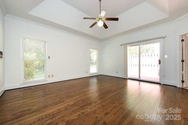 spare room featuring ceiling fan, dark hardwood / wood-style flooring, crown molding, and a raised ceiling