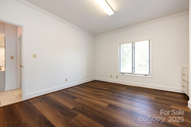 spare room featuring dark hardwood / wood-style flooring and crown molding