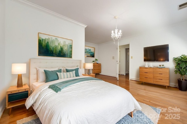 bedroom with wood-type flooring, an inviting chandelier, and crown molding