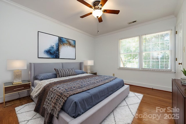 bedroom featuring ceiling fan, crown molding, and light wood-type flooring