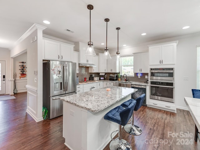 kitchen featuring white cabinets, sink, stainless steel appliances, and a center island