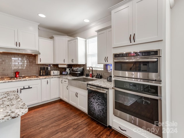 kitchen featuring decorative backsplash, sink, white cabinetry, stainless steel appliances, and dark hardwood / wood-style flooring