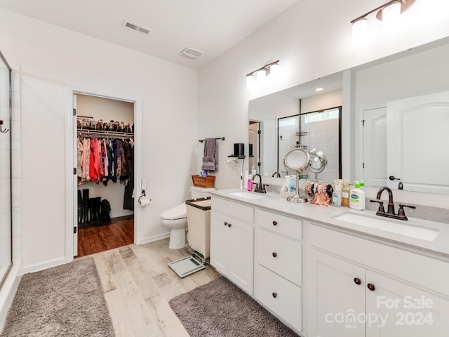 bathroom with a shower with shower door, vanity, toilet, and hardwood / wood-style flooring